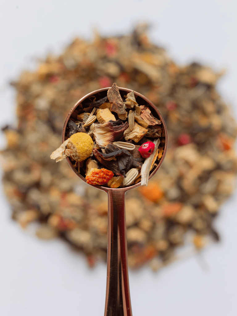 Une cuillère à thé doseuse contenant les ingrédients d'une tisane Relax ayurvédique
